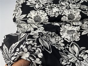 Fastvævet polyester voile - smukke blomster i råhvid på sort bund